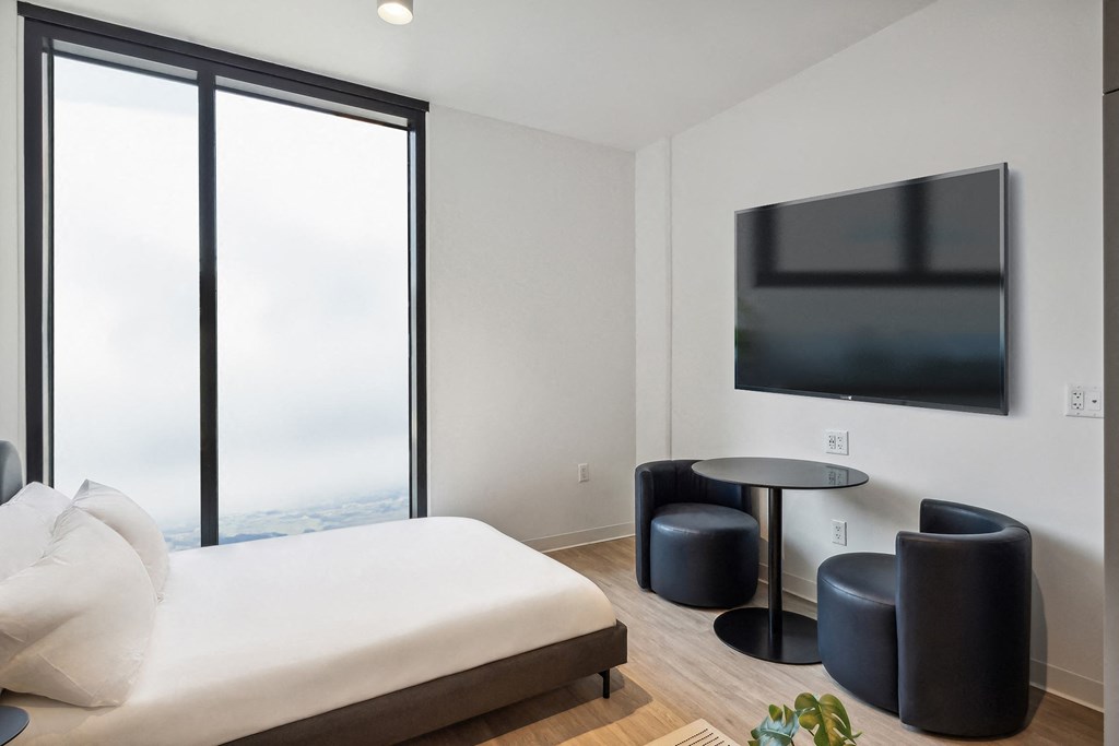 a hotel room with a bed and a television on the wall