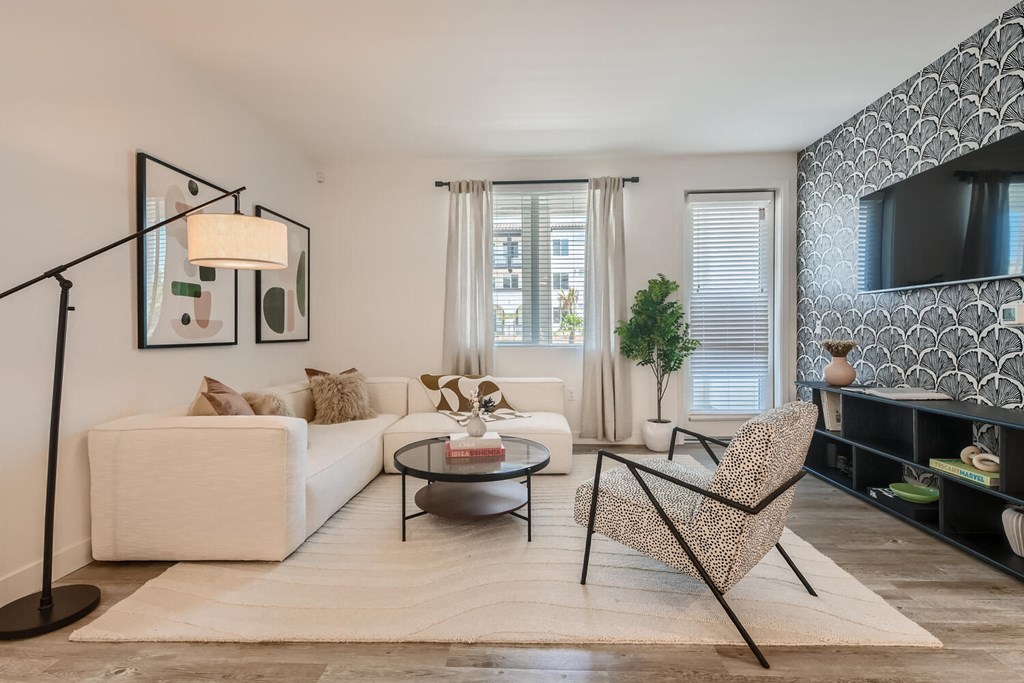 a living room with a white couch and a black coffee table at The Venue at Orange Apartments, Redlands, CA
