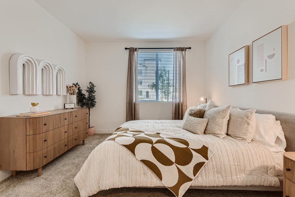 a bedroom with a bed and dresser at The Venue at Orange Apartments, Redlands, 92373
