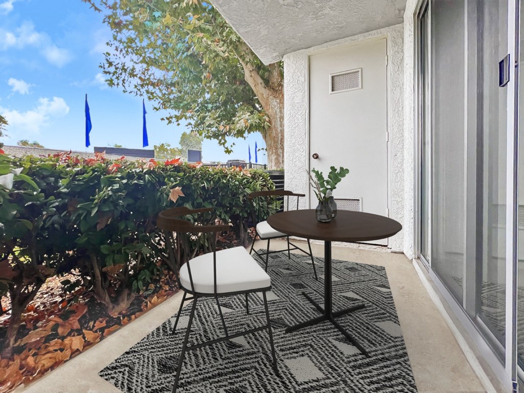 a small patio with a table and chairs and a window