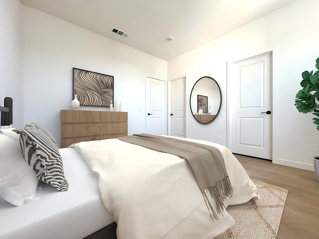 a bedroom with a white bed and a mirror on the wall at The Willow Townhomes, Ontario
