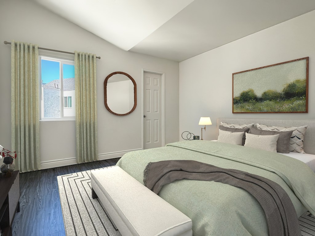 A bedroom with a bed, a mirror, a window with curtains, and a painting on the wall at Ridgeline Apartments in San Bernardino