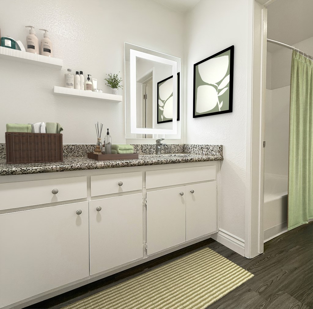 A bathroom with white cabinets and a marble countertop at Ridgeline Apartments in San Bernardino