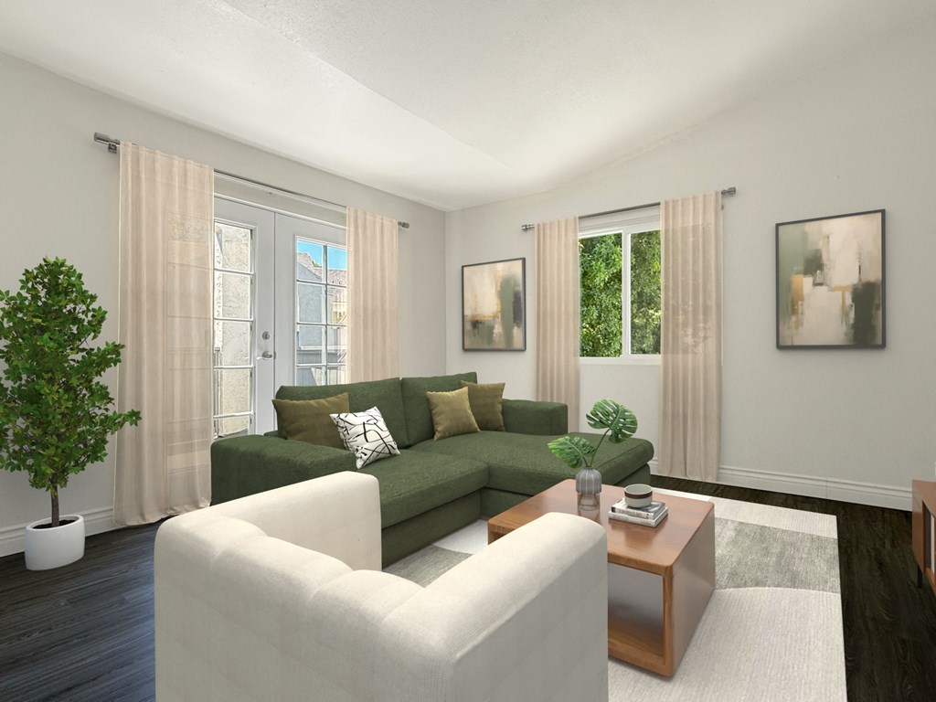 A living room with a green couch, a white chair, and a potted plant at Ridgeline Apartments in San Bernardino
