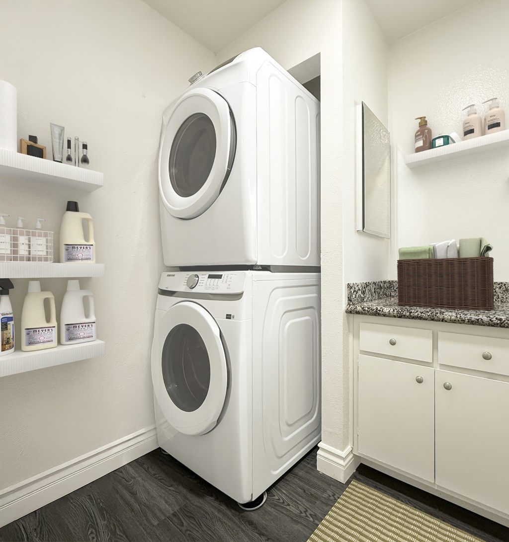 A white front loading washing machine in a laundry room at Ridgeline Apartments in San Bernardino