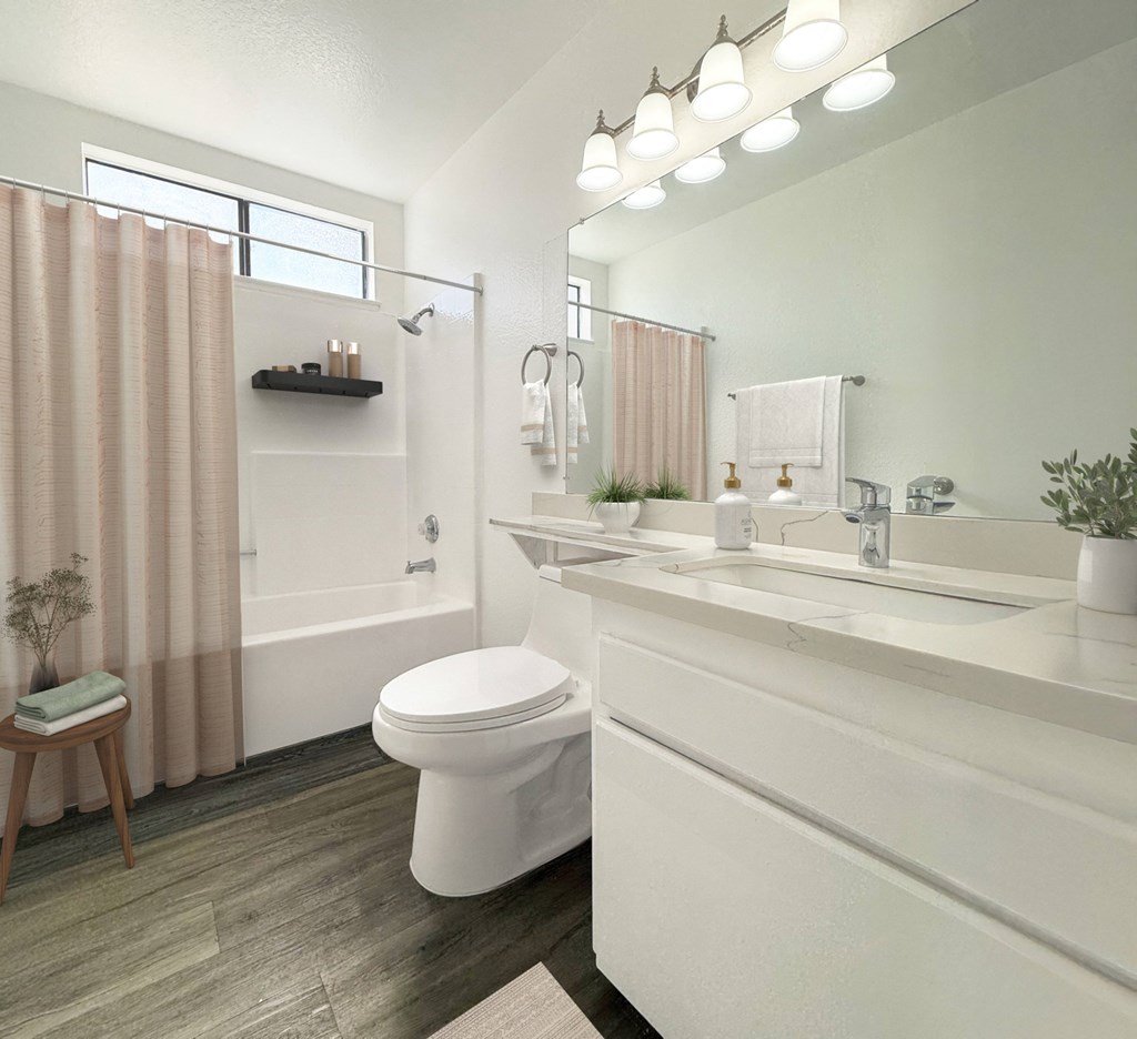 A white toilet sits in a bathroom next to a sink at Charlmont Village Apartments, Ontario, CA 91764