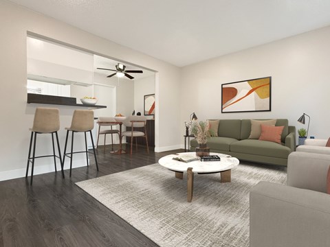 A modern living room with a grey sofa, a wooden coffee table, and a dining table set up.