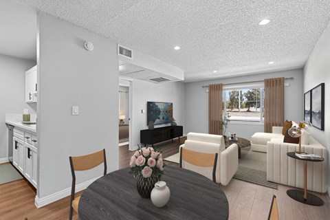 A modern living room with a grey table and white chairs.