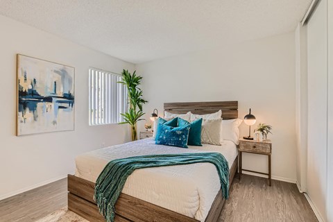 A bedroom with a large bed and a painting on the wall.