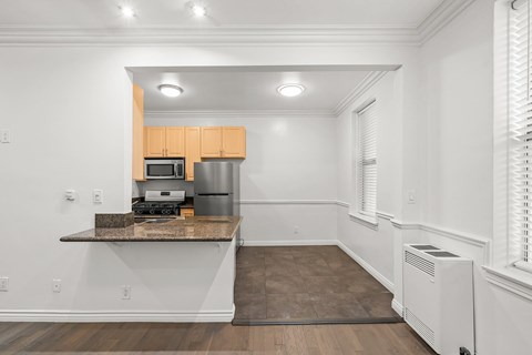 A kitchen with wooden cabinets and a granite countertop.