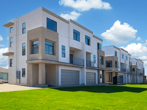 a row of houses with a green lawn in front of them