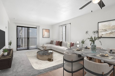 A modern living room with a glass coffee table and a grey sofa.