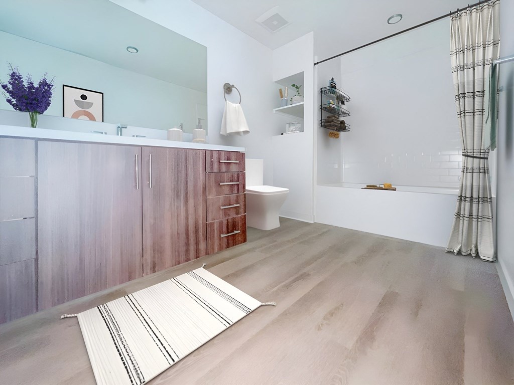 a bathroom with a wooden vanity and a shower and a toilet at The Max on Jefferson Apartments, Murrieta