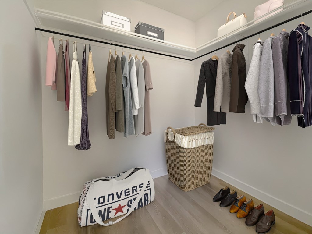 a walk in closet with a rack of clothes and shoes at The Max on Jefferson Apartments, California, 92562