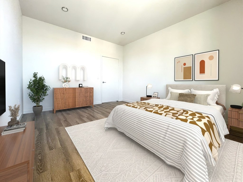 a bedroom with white walls and a bed with a leopard blanket at The Max on Jefferson Apartments, Murrieta