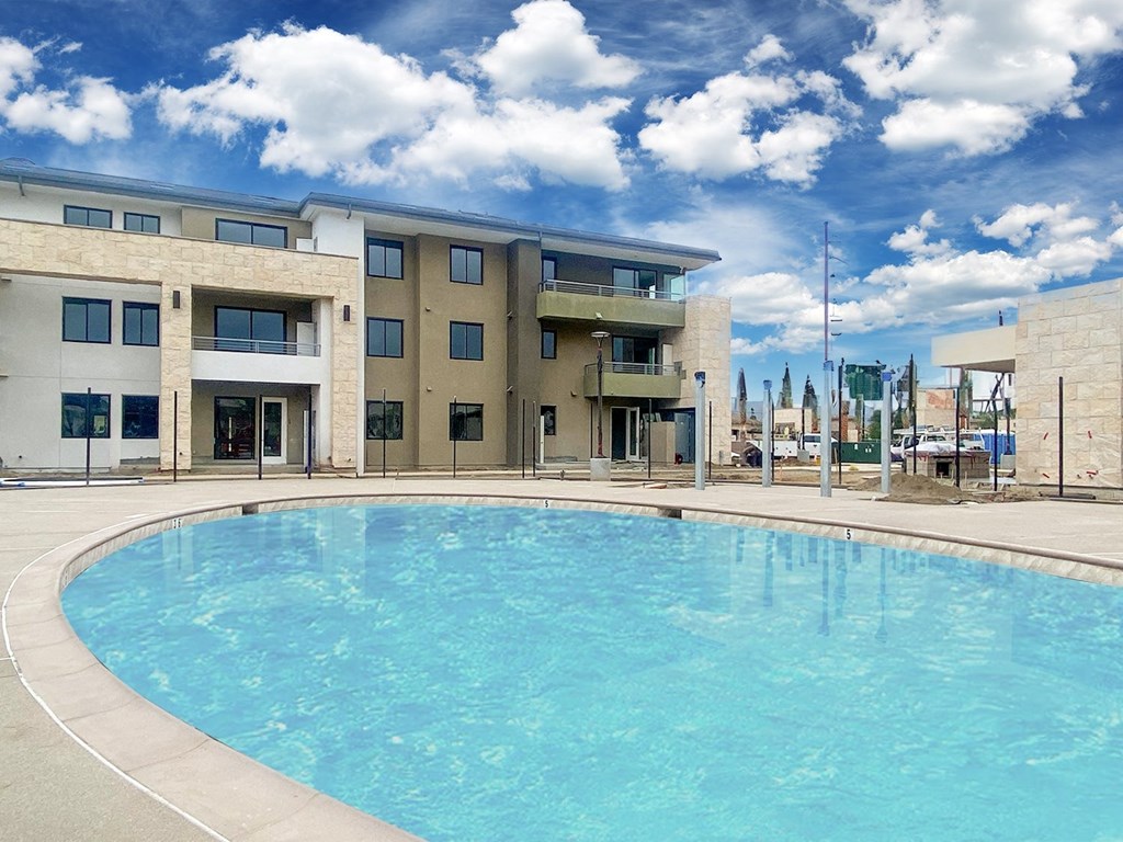 a large swimming pool in front of a building at The Max on Jefferson Apartments, California