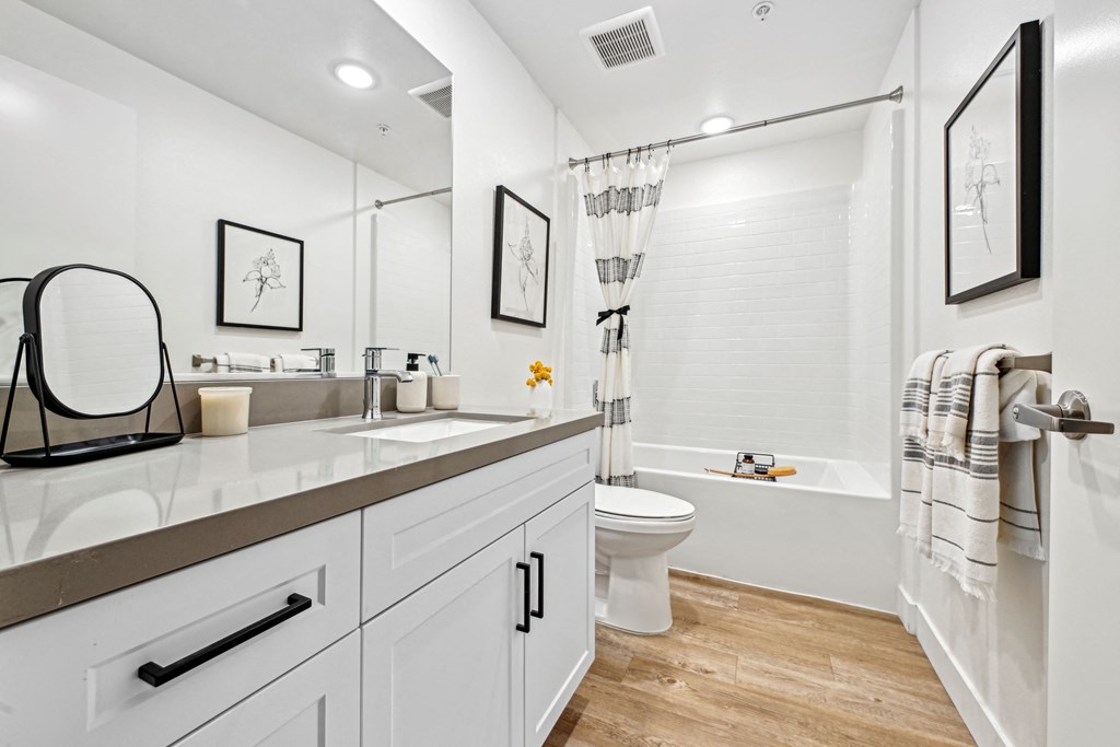 a white bathroom with a shower toilet and sink at The Venue at Orange Apartments, California, 92373