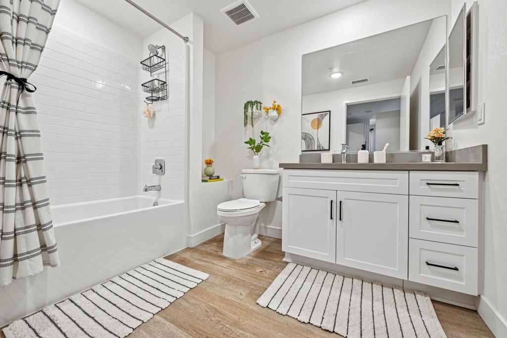 a white bathroom with a shower and a toilet at The Venue at Orange Apartments, California, 92373