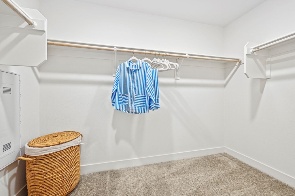 our spacious walk in closet is loaded with clothes and towels and has a large closet at The Venue at Orange Apartments, California