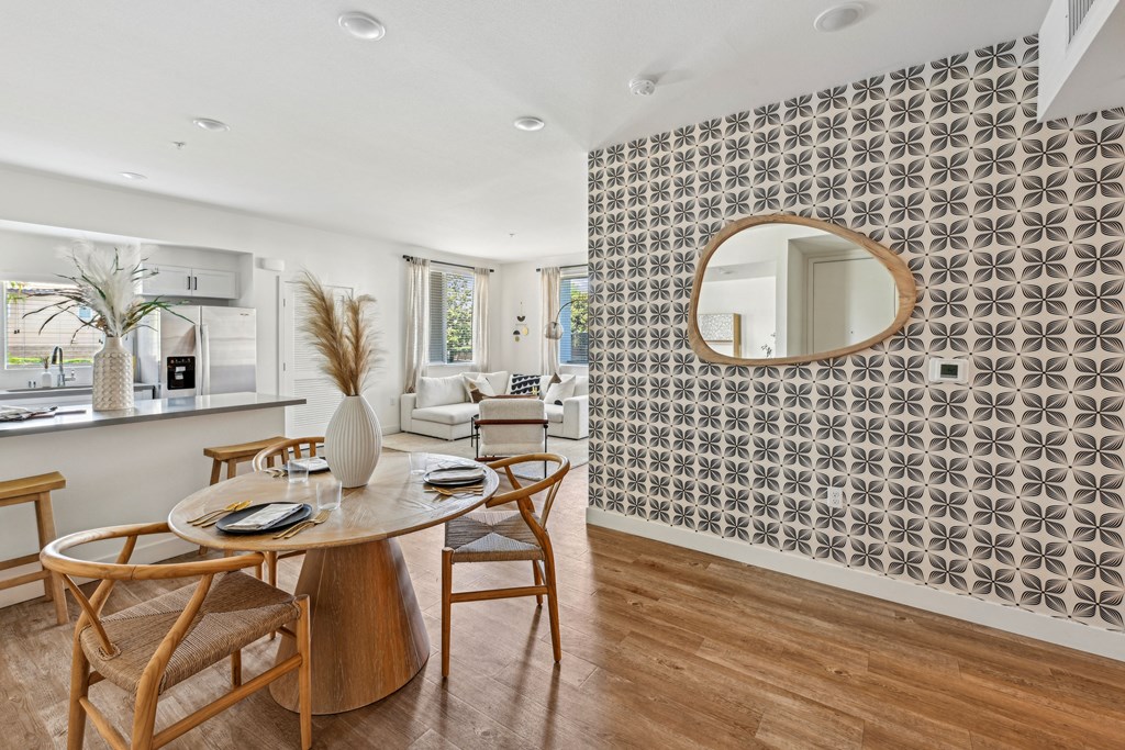 a dining room with a table and chairs and a mirror at The Venue at Orange Apartments, Redlands, 92373