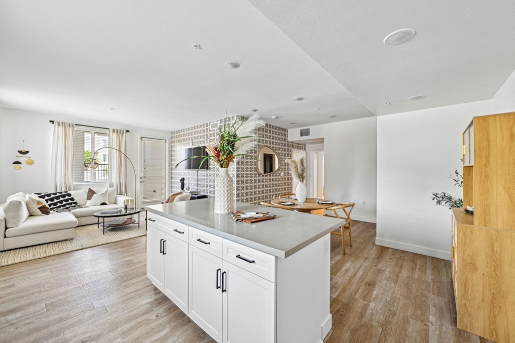 a kitchen with a large island and a living room at The Venue at Orange Apartments, Redlands