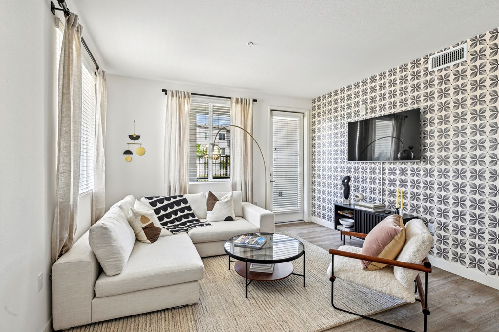 a living room with a couch and a chair and a television at The Venue at Orange Apartments, Redlands, California
