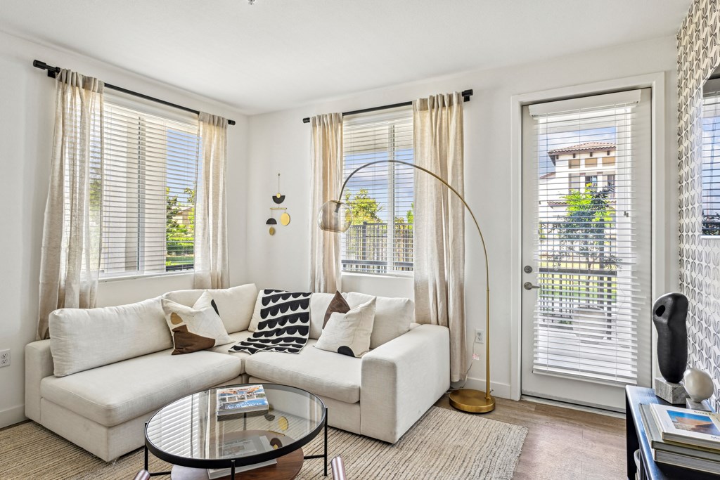 a living room with a white couch and a glass coffee table at The Venue at Orange Apartments, California