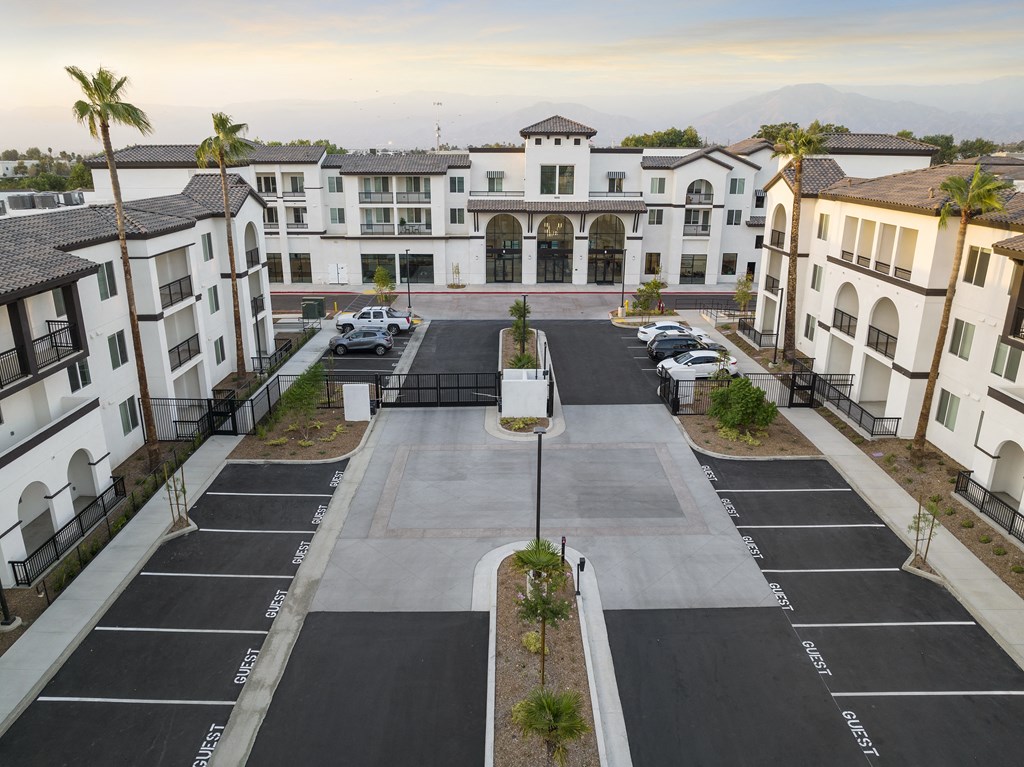 an aerial view of an empty parking lot in front of houses at The Venue at Orange Apartments, Redlands, CA, 92373