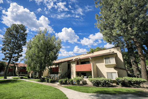 A row of houses with trees in front.