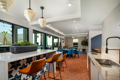 A kitchen with orange chairs and a counter.