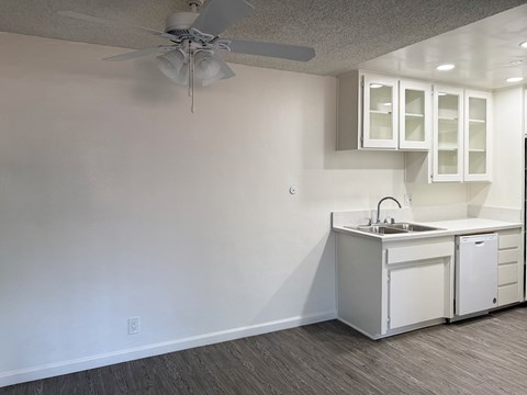 A white kitchen with a fan on the ceiling.