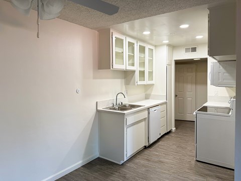 A kitchen with white cabinets and a sink.