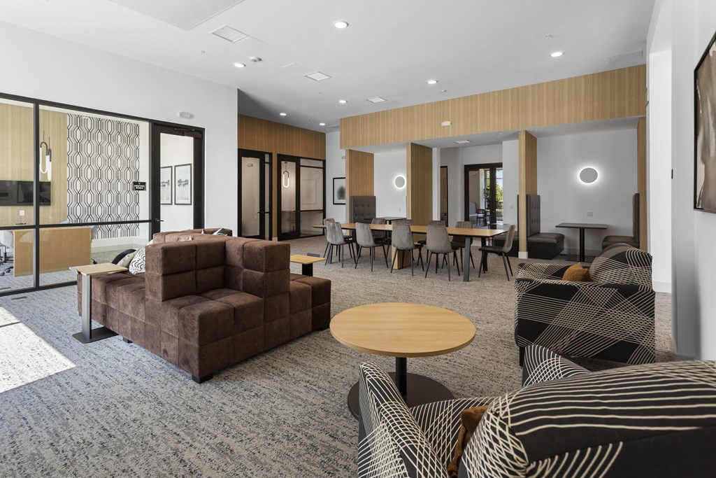 a living room with couches and chairs and a dining room with tables at The Venue at Orange Apartments, Redlands, CA