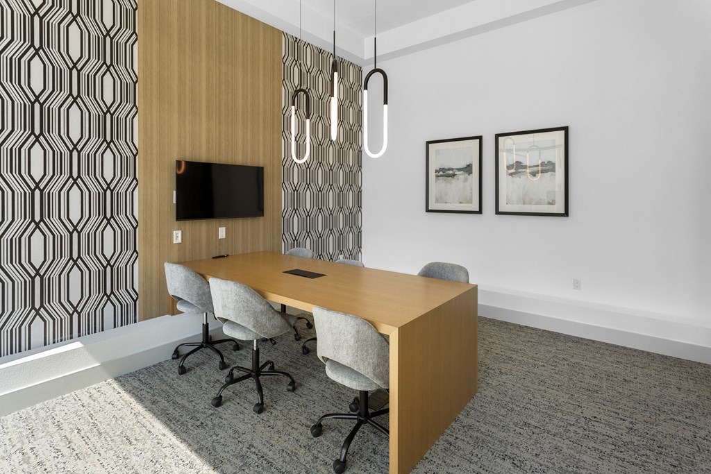 a conference room with a wooden desk and chairs at The Venue at Orange Apartments, California