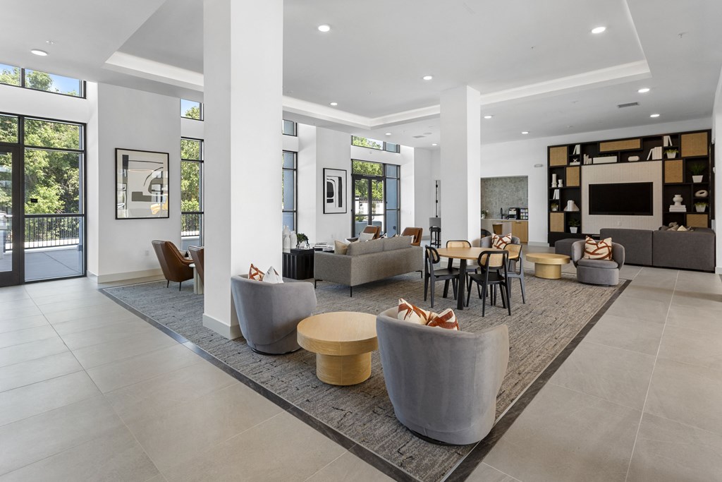 a living room with couches and chairs and a television at The Venue at Orange Apartments, California