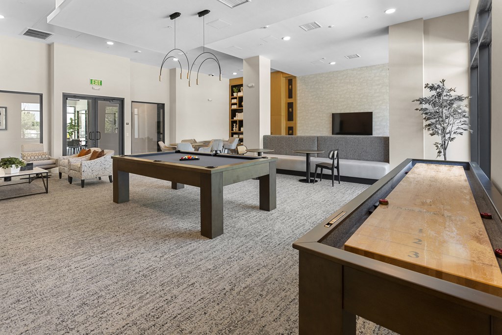 two billiards tables in the clubhouse of a community center with a pool table at The Venue at Orange Apartments, California