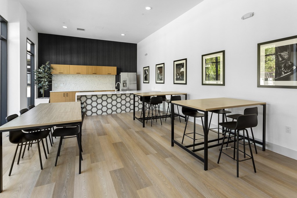 a dining room with tables and chairs and a kitchen at The Venue at Orange Apartments, California, 92373