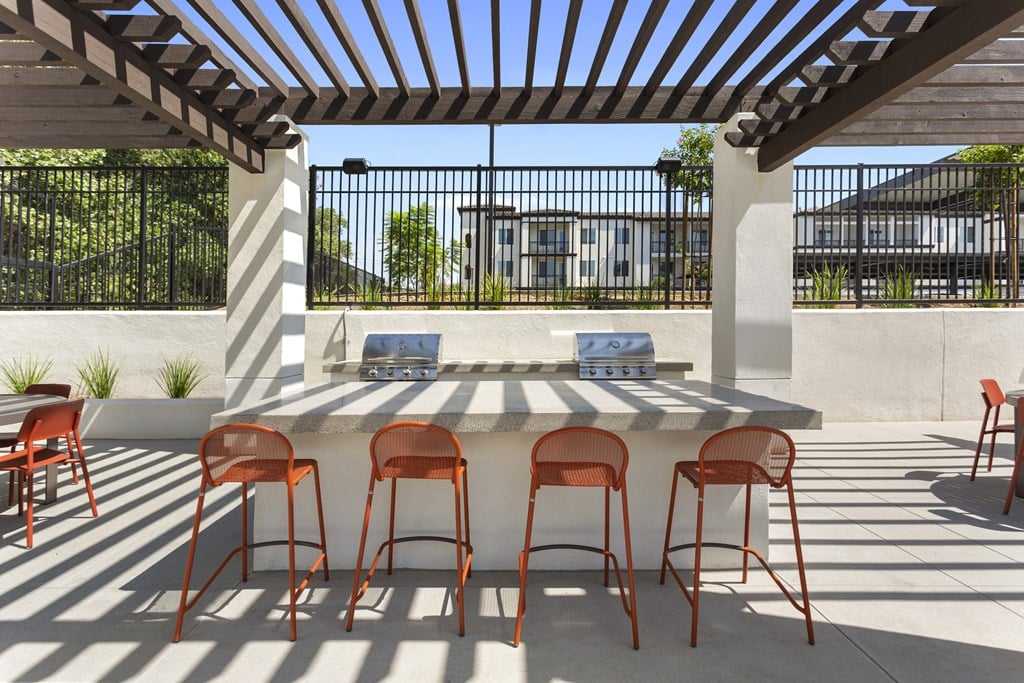 a patio with a bar with chairs and a table at The Venue at Orange Apartments, California, 92373