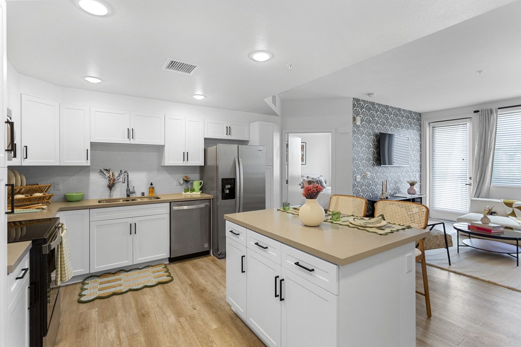 an open kitchen and living room with white cabinets and stainless steel appliances at The Venue at Orange Apartments, Redlands, CA, 92373