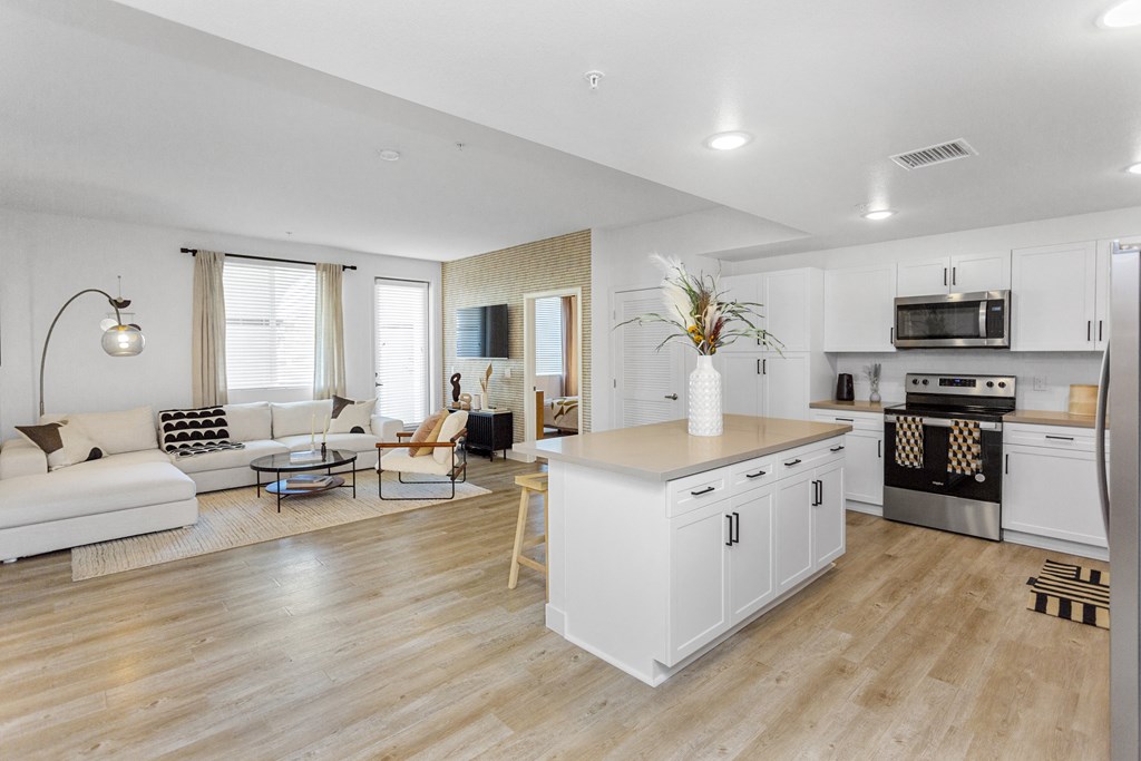 a living room with a kitchen and a couch at The Venue at Orange Apartments, California
