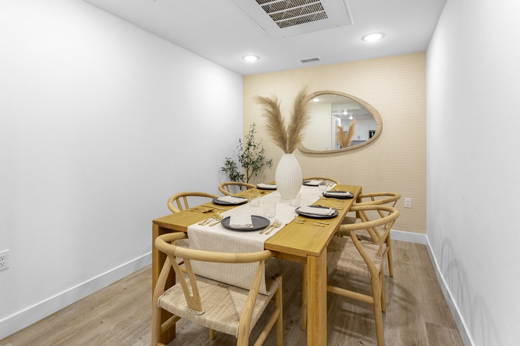 a dining room with a wooden table and chairs at The Venue at Orange Apartments, Redlands, CA, 92373