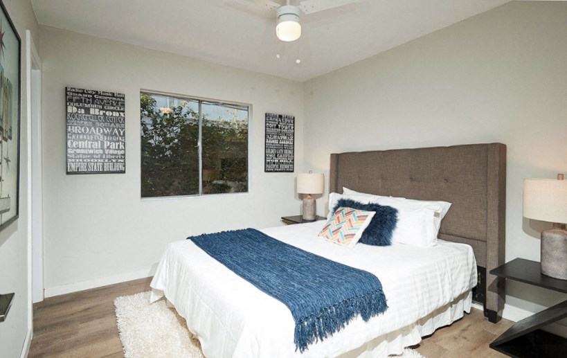 a bedroom with a bed and two windows