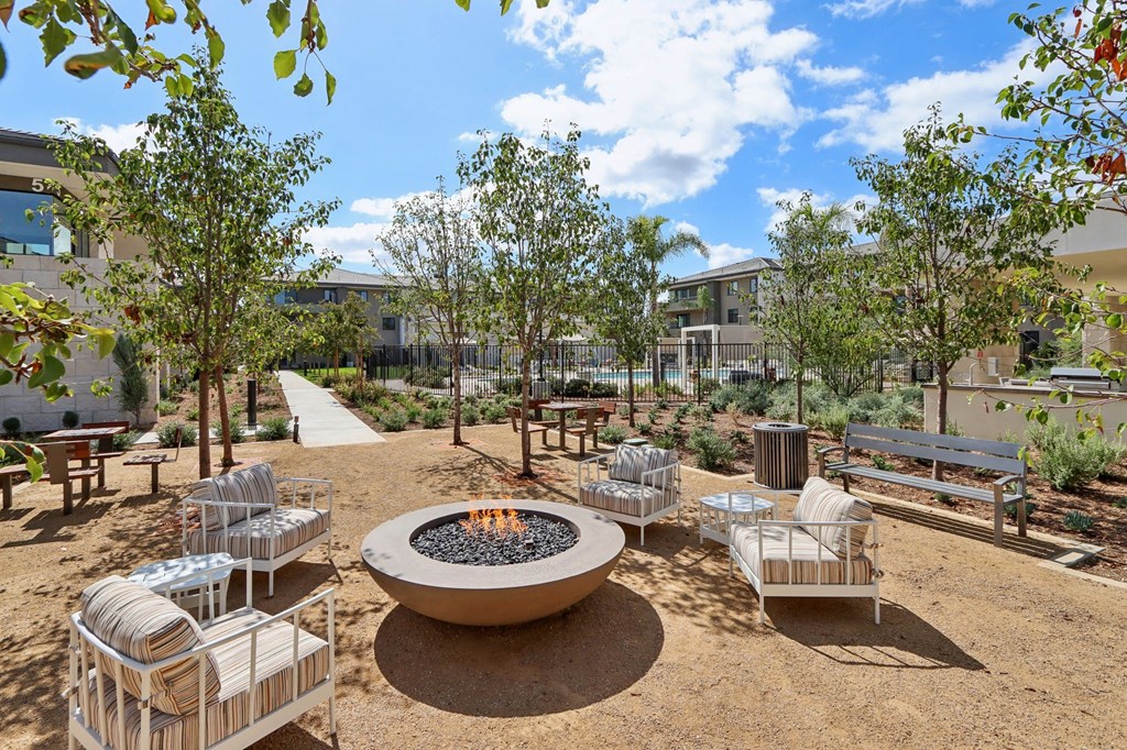 an outdoor patio with a fire pit and benches at The Max on Jefferson Apartments, Murrieta, 92562