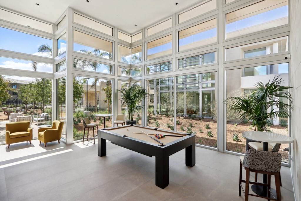 a billiards table in a room with glass walls at The Max on Jefferson Apartments, Murrieta