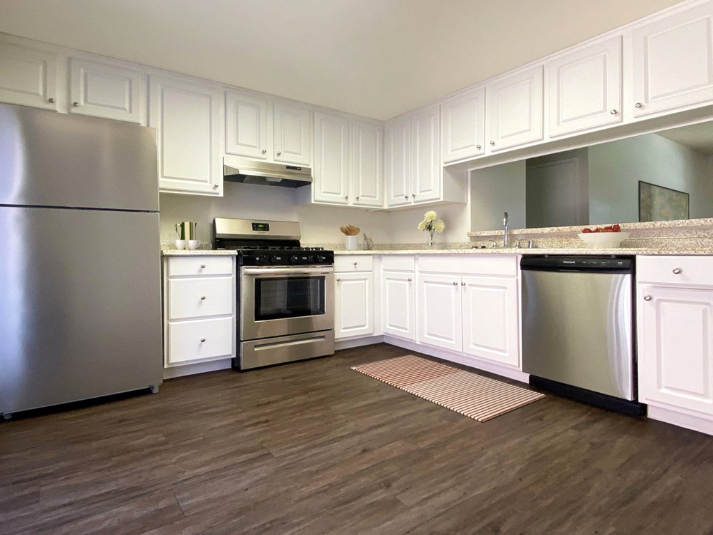 a large kitchen with stainless steel appliances and white cabinets at Summer Meadows, Riverside, CA, 92507