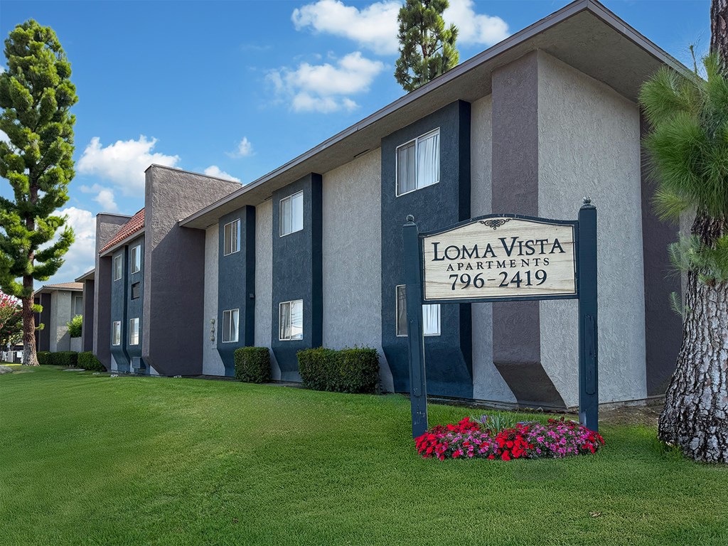 A row of apartment buildings with a sign that says Loma Vista Apartments.