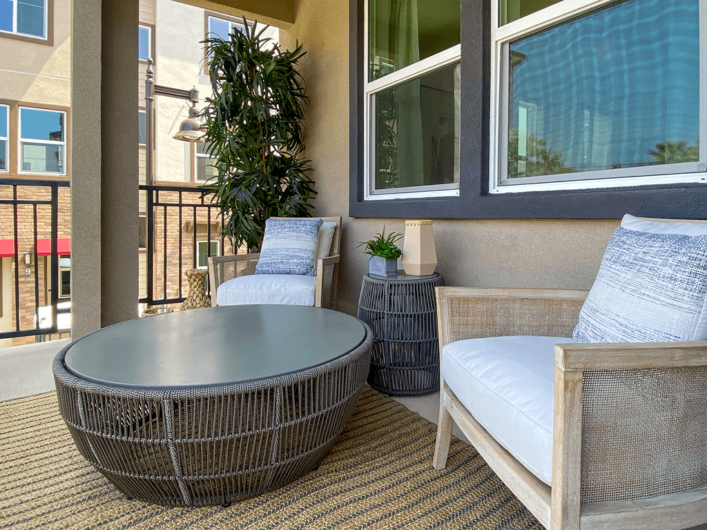 a living room with a table and chairs and a balcony