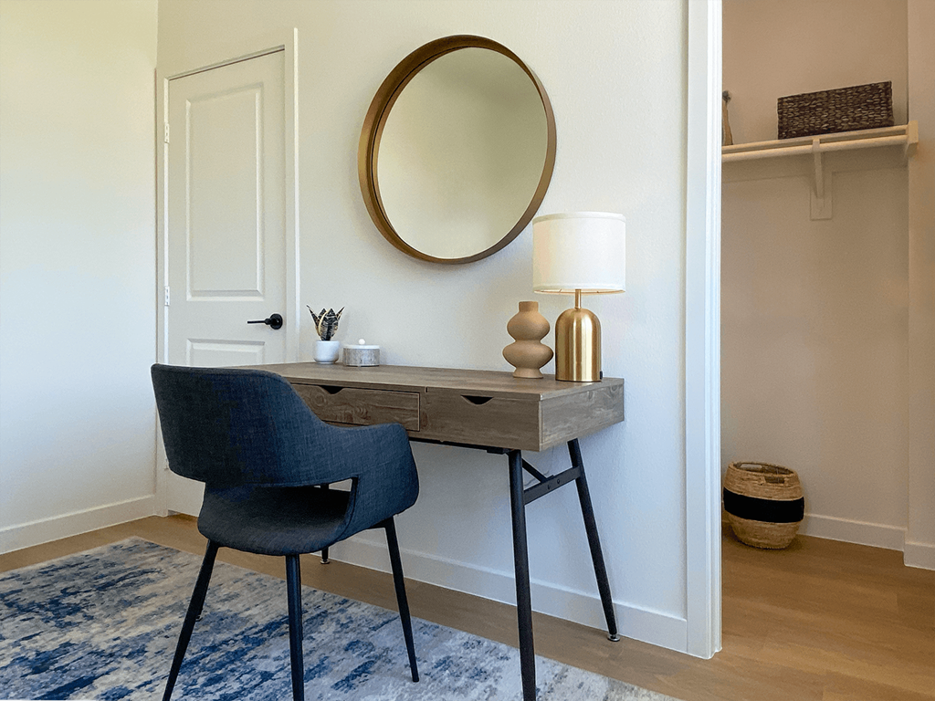 a desk with a mirror and a chair in a room