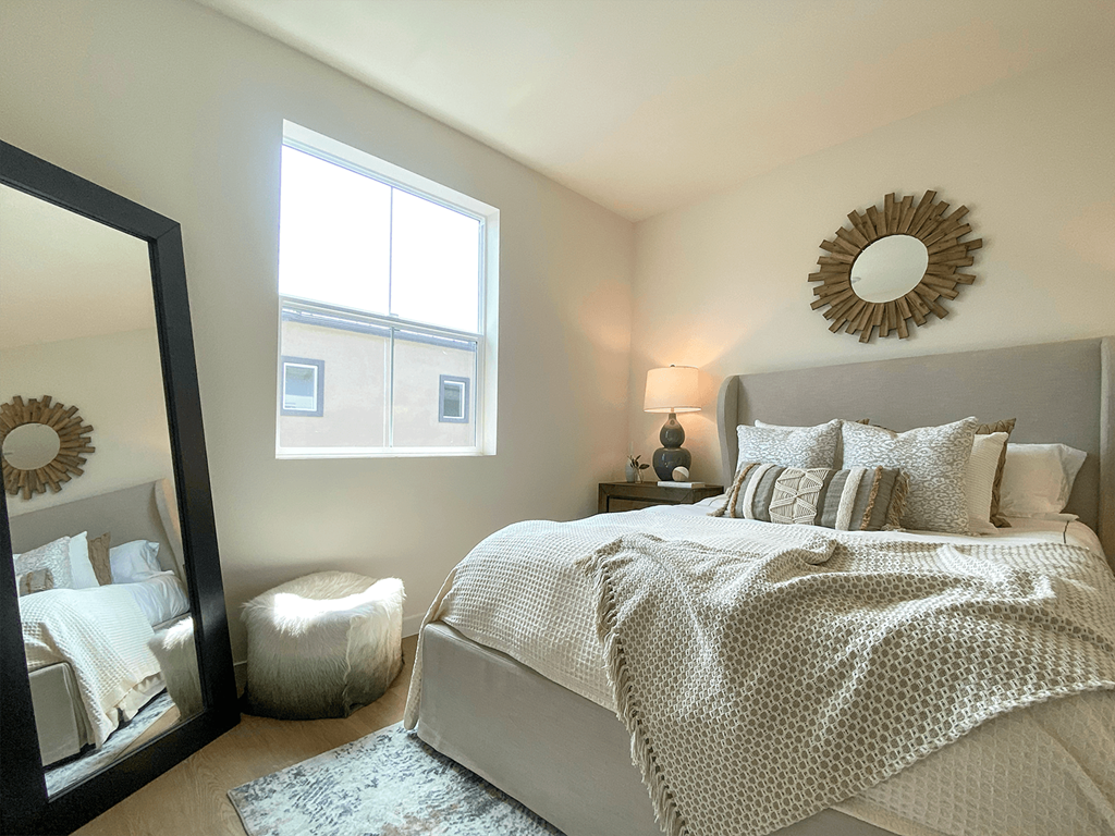 a bedroom with a large bed and a mirror