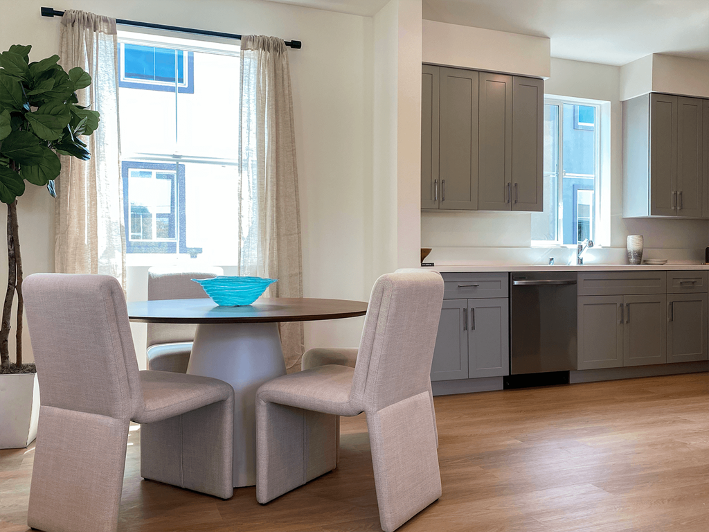 a kitchen with a table and chairs in front of a window